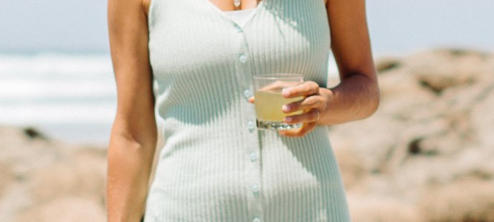 A woman at the beach enjoying a Your Super drink